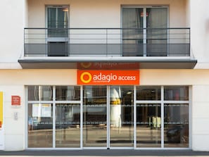 Un immeuble sur lequel on peut lire l’inscription : « Adagio, accès centre-ville, appartements ».