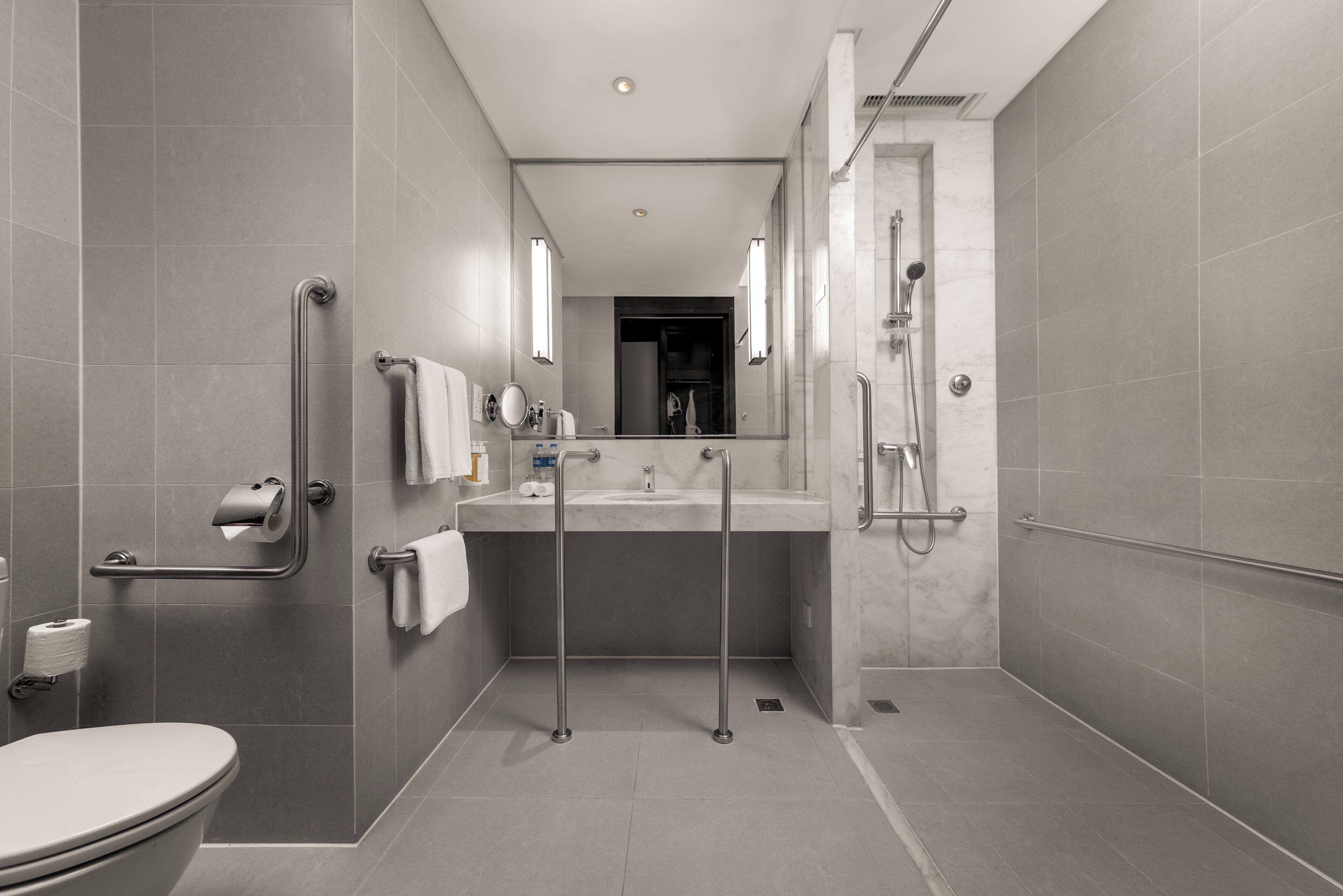 A modern bathroom with a toilet, sink, and shower.