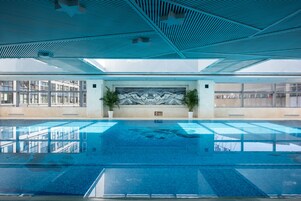 Una piscina techada, sillones reclinables de piscina