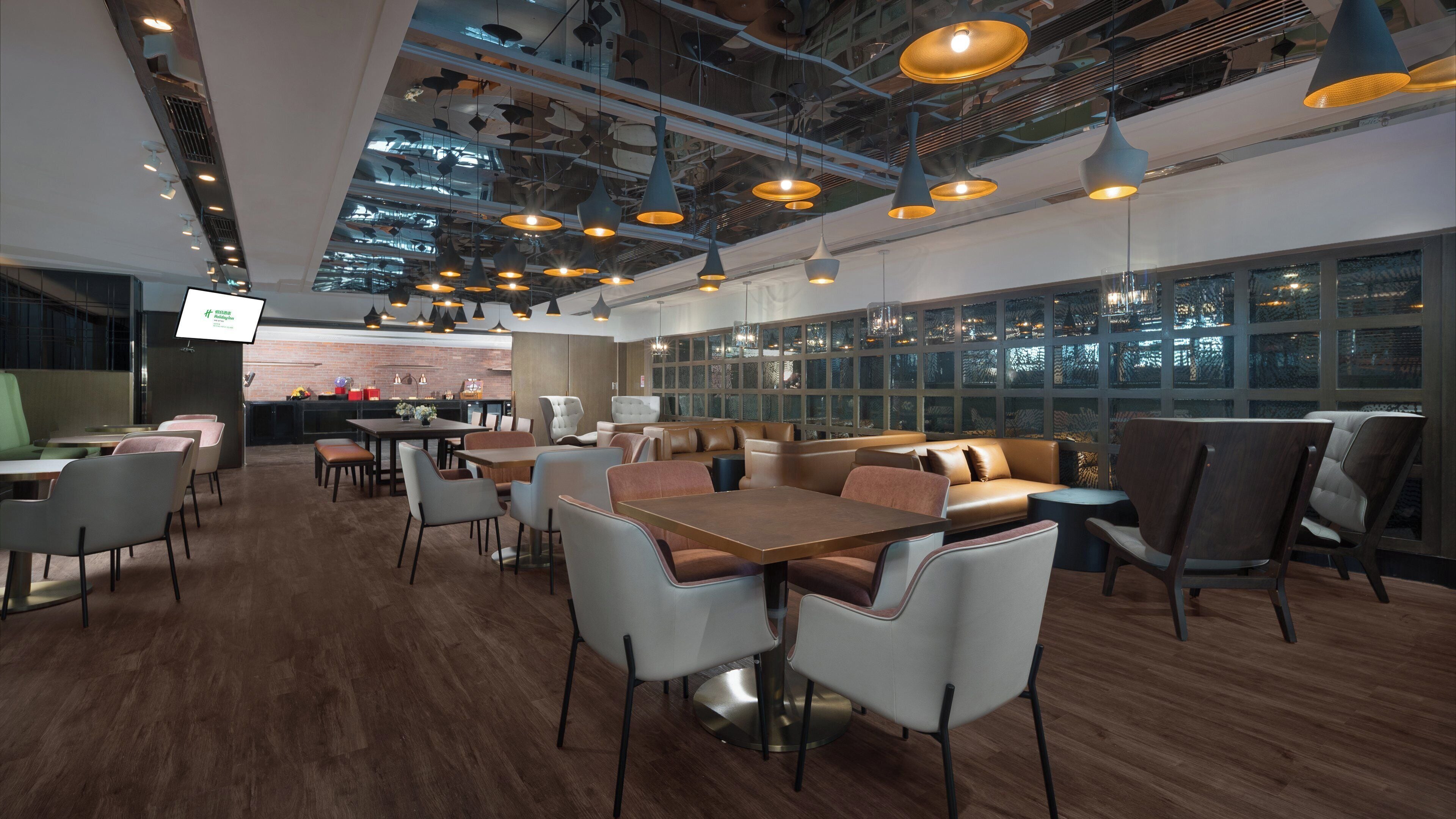 A modern interior with dining tables, chairs, and hanging pendant lights.