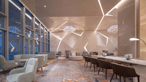 A modern hotel lobby with a large seating area, a long table, and a patterned carpet. - Holiday Inn Beijing Focus Square by IHG (Beijing)
