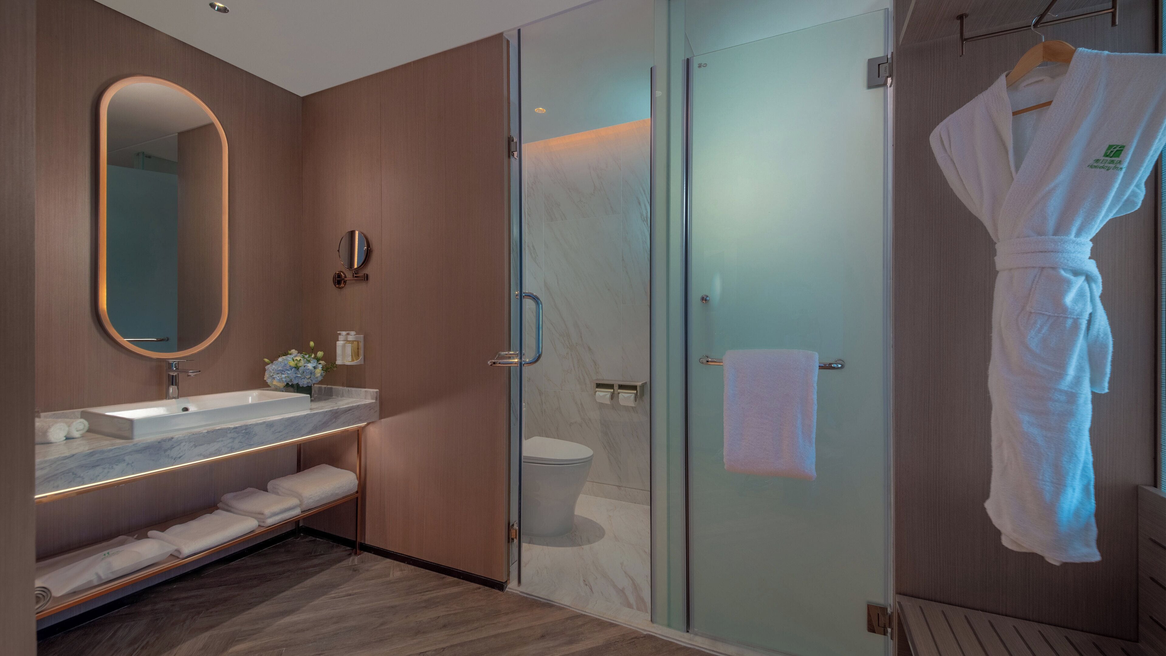Une salle de bain moderne avec une douche à parois de verre, un lavabo en marbre et un meuble-lavabo en bois.