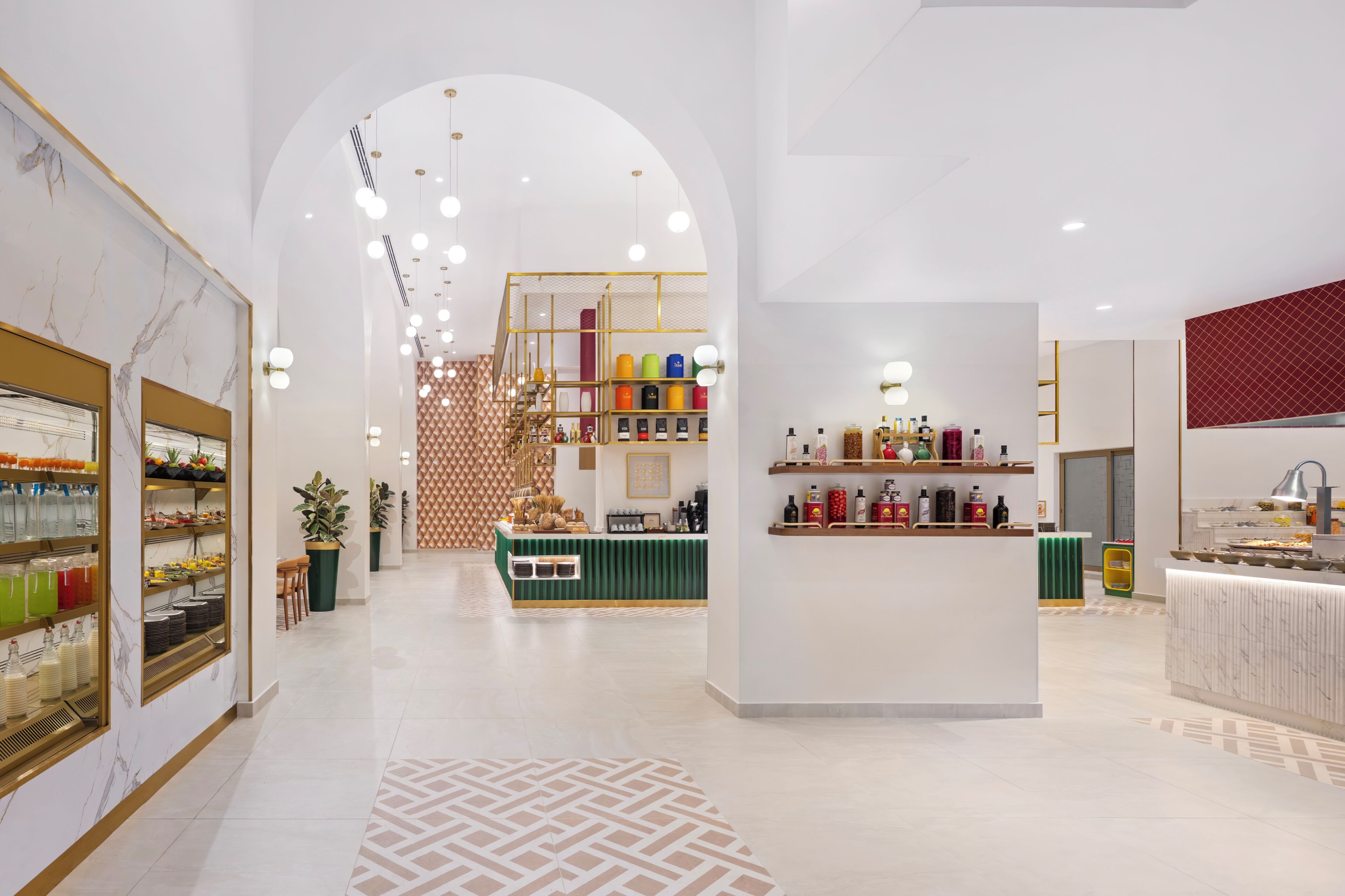 Ein modernes Interieur mit einer zentralen Kochinsel, umgeben von verschiedenen Speise- und Getränkestationen.