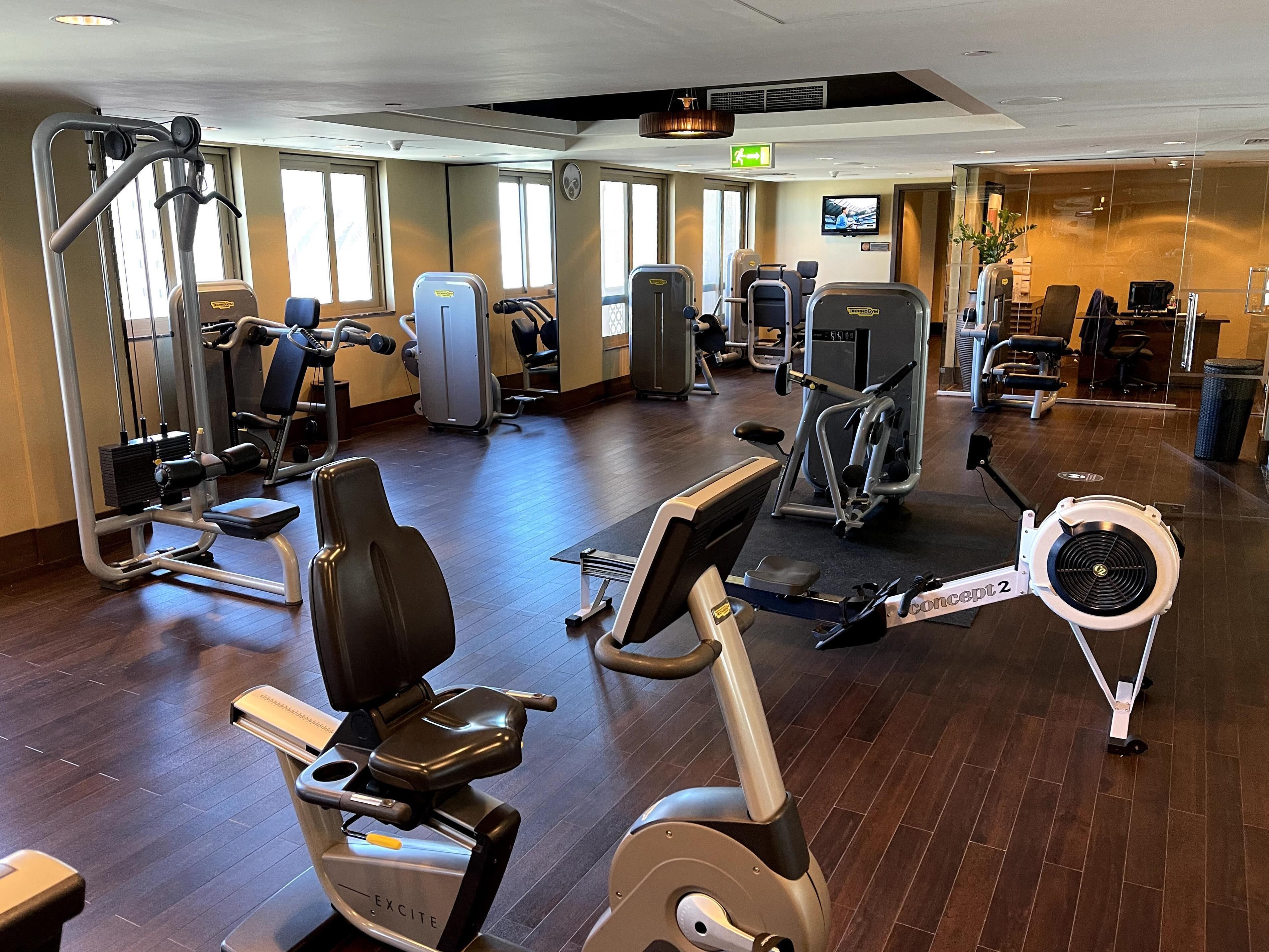 A gym with various exercise equipment, including treadmills, stationary bikes, and weight machines.