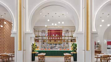 A modern interior with a central serving area, multiple seating arrangements, and a distinctive geometric wall pattern.