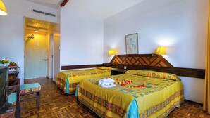 Una habitación de hotel con dos camas, un televisor, un escritorio y una silla.