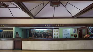 A reception desk with a mural, a clock, and a framed picture.