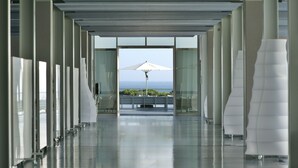 Ein moderner Hotelgang mit Meerblick durch große Fenster.