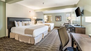 A hotel room with two beds, a desk, a chair, and a TV mounted on the wall. - The Valley Inn, an Ascend Collection Hotel (Waterville Valley)