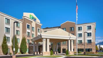 A hotel with a covered entrance, multiple floors, and a flagpole with the American flag.