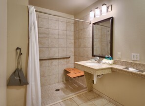 Une salle de bain avec une douche, un lavabo et un miroir.