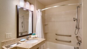 A bathroom with a granite countertop sink, a mirror, a shower with a handheld showerhead, and a towel rack. - Holiday Inn Express & Suites Orem-North Provo by IHG (Orem)