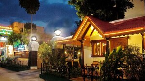 Een restaurant met terras, een bord met 'Golden Palite' erop, en een goed verlichte ingang.