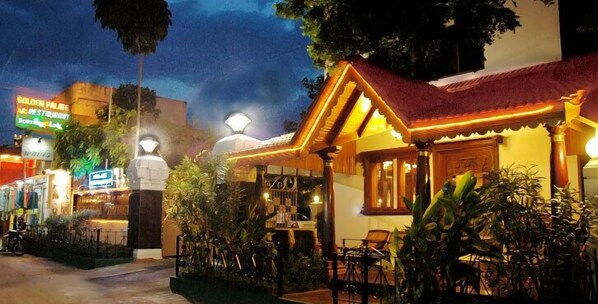 A restaurant with outdoor seating, a sign for 'Golden Palite', and a well-lit entrance.