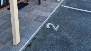 Un motel doté d’un espace extérieur abrité avec des sièges, de murs en briques et d’un parking.