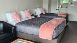 Une chambre d’hôtel avec deux lits, une armoire, un bureau et un miroir.