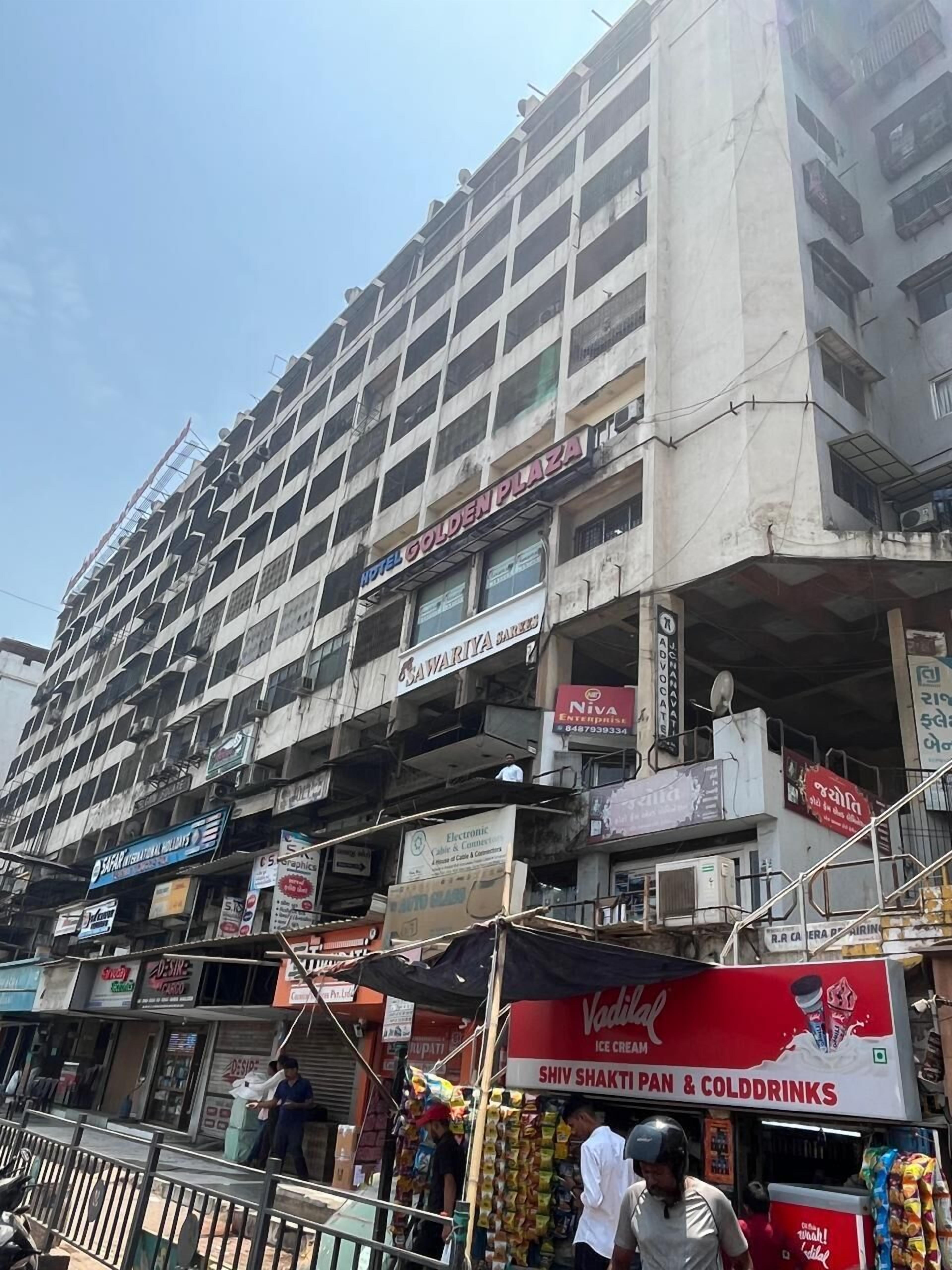 A multi-story building with signs for 'Hotel Golden Plaza' and 'Swarikya Sarovar'.