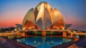 A large, lotus-shaped building with a central pool. - Goldfinch Hotel Delhi NCR (Faridabad)