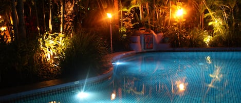 Una piscina al aire libre, sillones reclinables de piscina