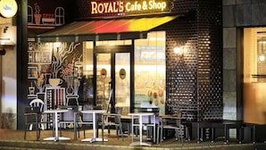 A restaurant named "ROYAL'S Cafe & Shop" with outdoor seating and a brick facade.