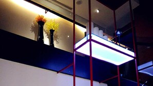 Un intérieur moderne avec un escalier, une étagère ornée de fleurs et un vase rempli de fleurs.