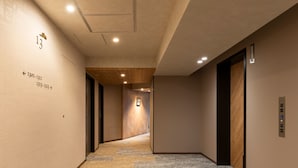 Un couloir doté d’un sol recouvert de moquette, de murs lambrissés et d’un plafond pourvu d’un éclairage encastré.