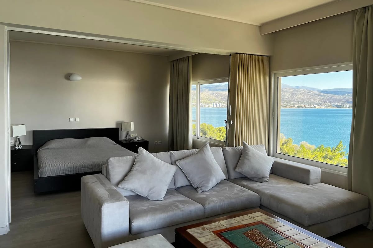 Un moderno cuarto de hotel con una cama grande, un sofá y vistas a un lago.