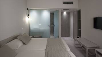 A modern bedroom with a bed, bedside table, and a TV mounted on the wall.