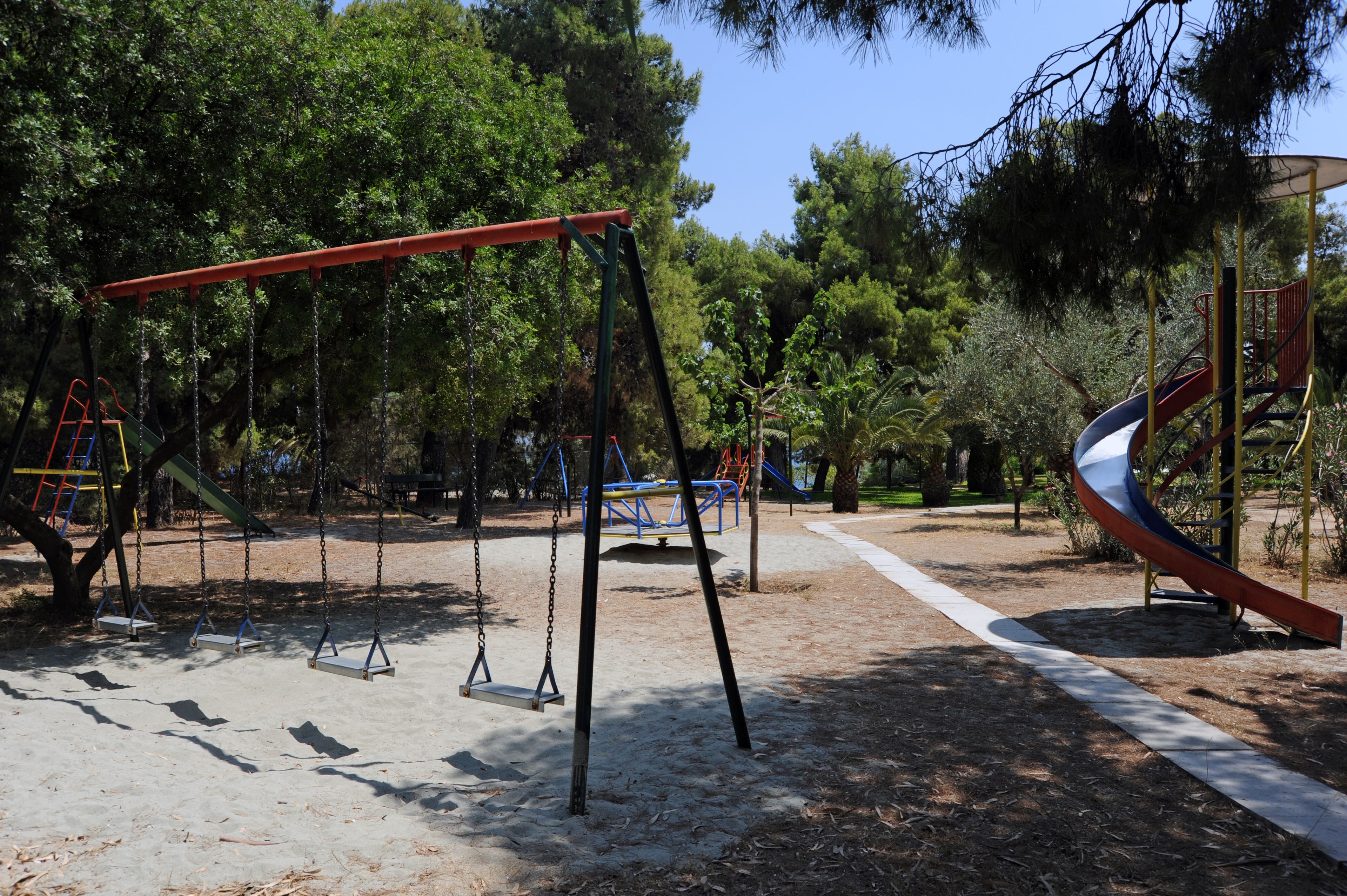 Un parque infantil con columpios, tobogán y estructuras para escalar.