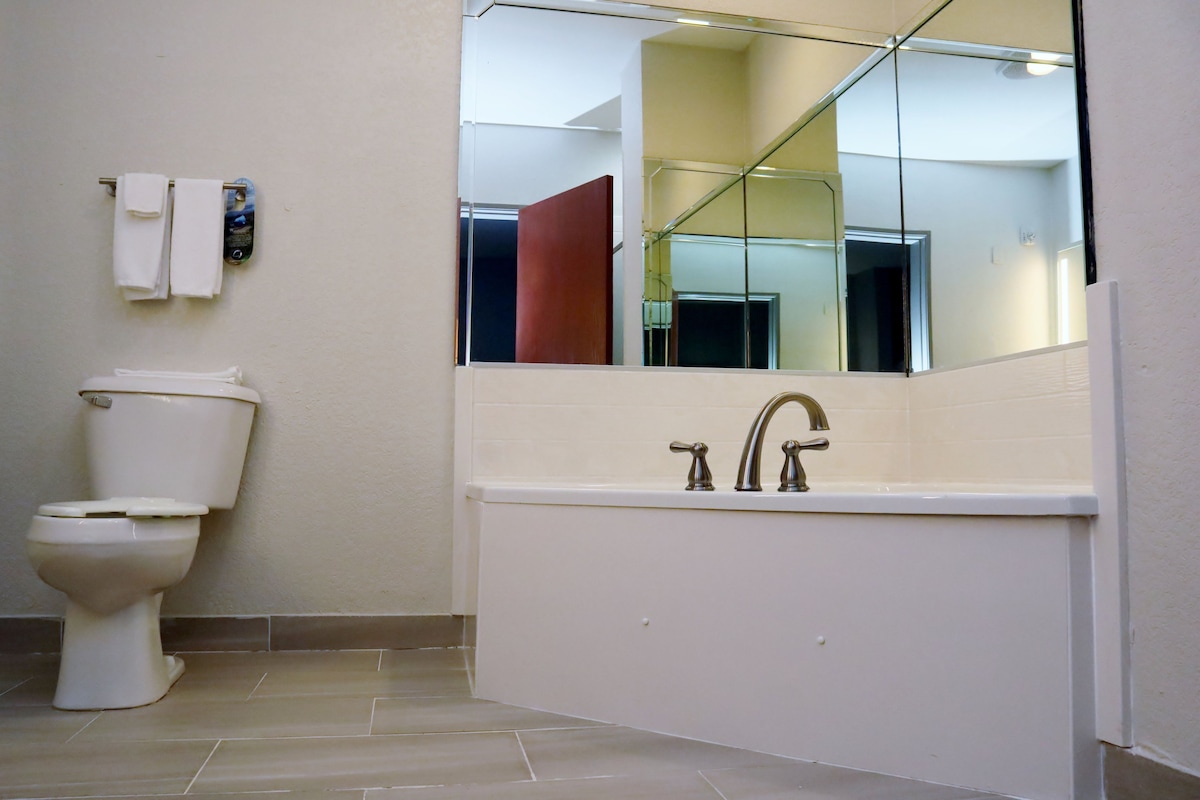 A bathroom with a toilet, a sink, and a mirror.