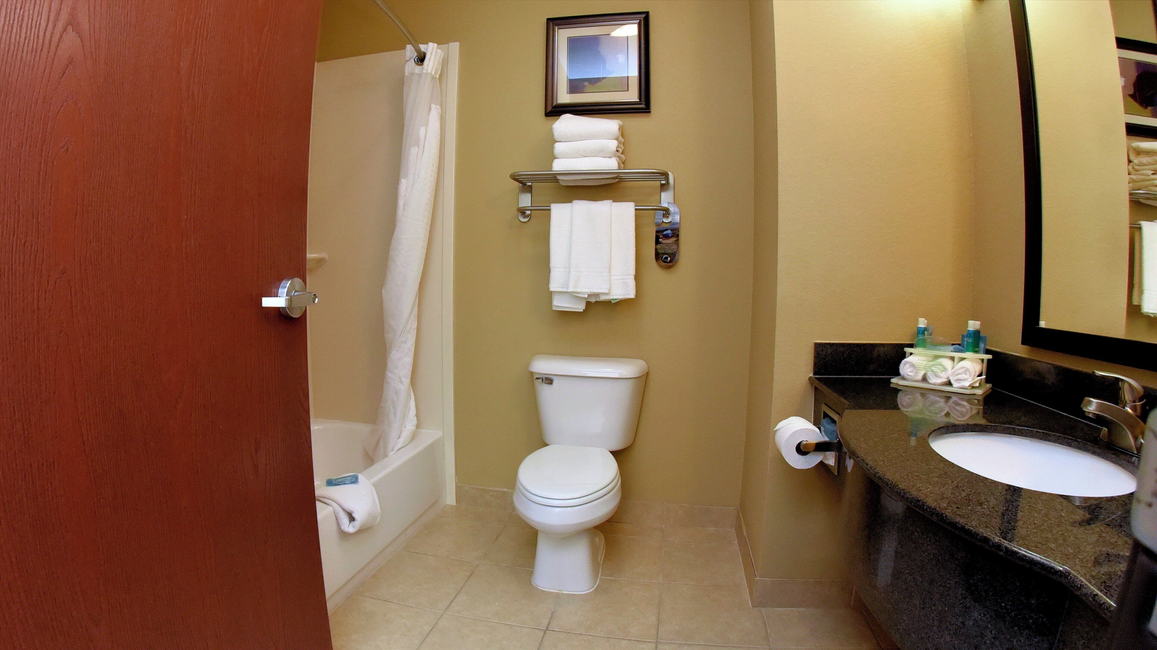 A bathroom with a toilet, a bathtub, a sink, and a towel rack.