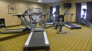 A hotel fitness center with multiple treadmills, stationary bikes, and a weight machine. - Holiday Inn Express Hotel & Suites Baton Rouge North by IHG (Zachary)