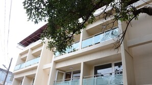 A multi-story hotel with balconies, a sign for 'HOTEL SUNNY INTERNATIONAL', and a tree in front. - Hotel Sunny International (Mahabaleshwar)