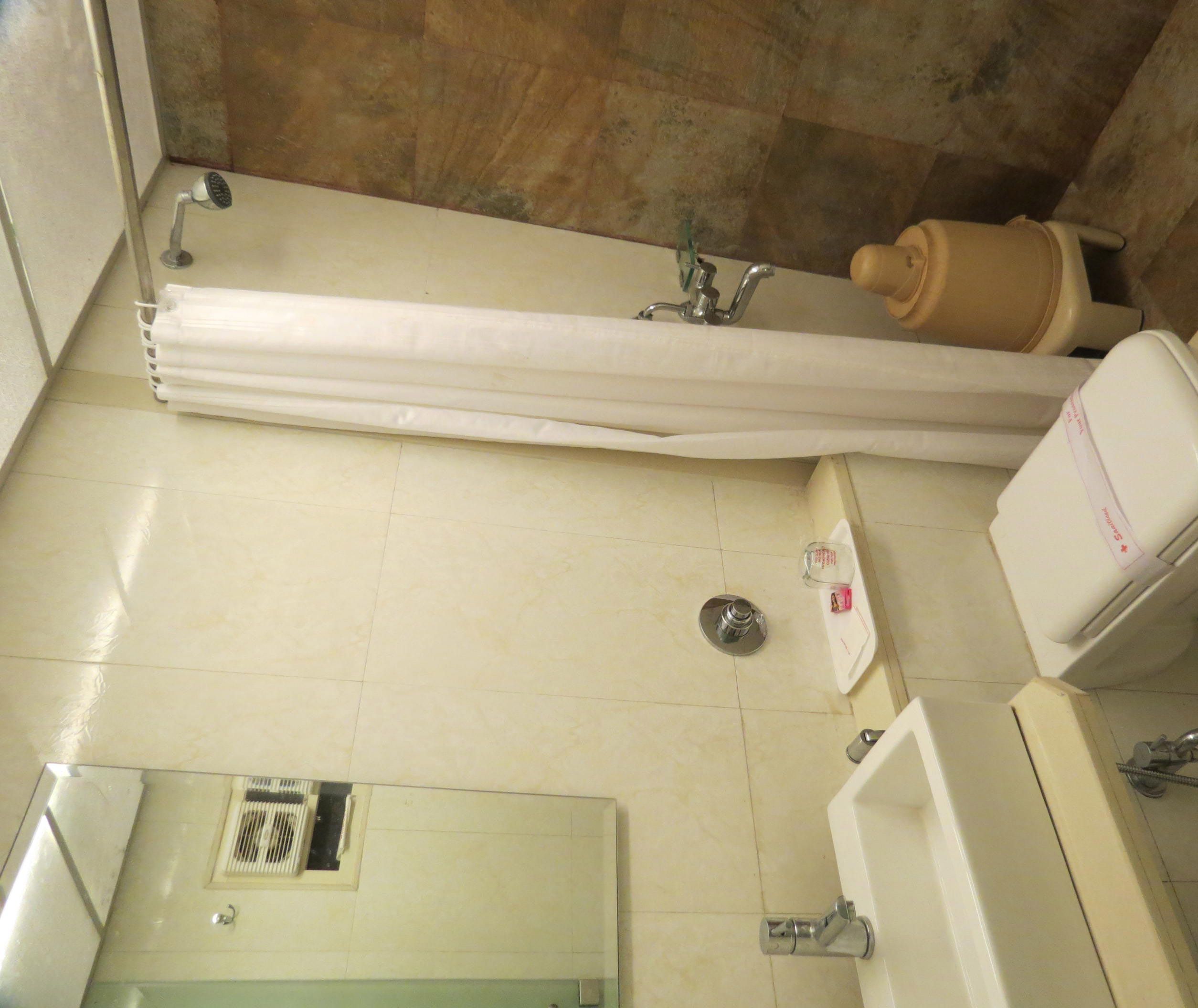 A bathroom with a bathtub, a toilet, a sink, and a showerhead.