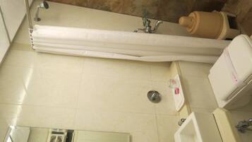 A bathroom with a bathtub, a toilet, a sink, and a showerhead.