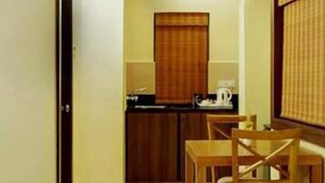 Una cocina pequeña con un armario de madera, una mesa y una silla.