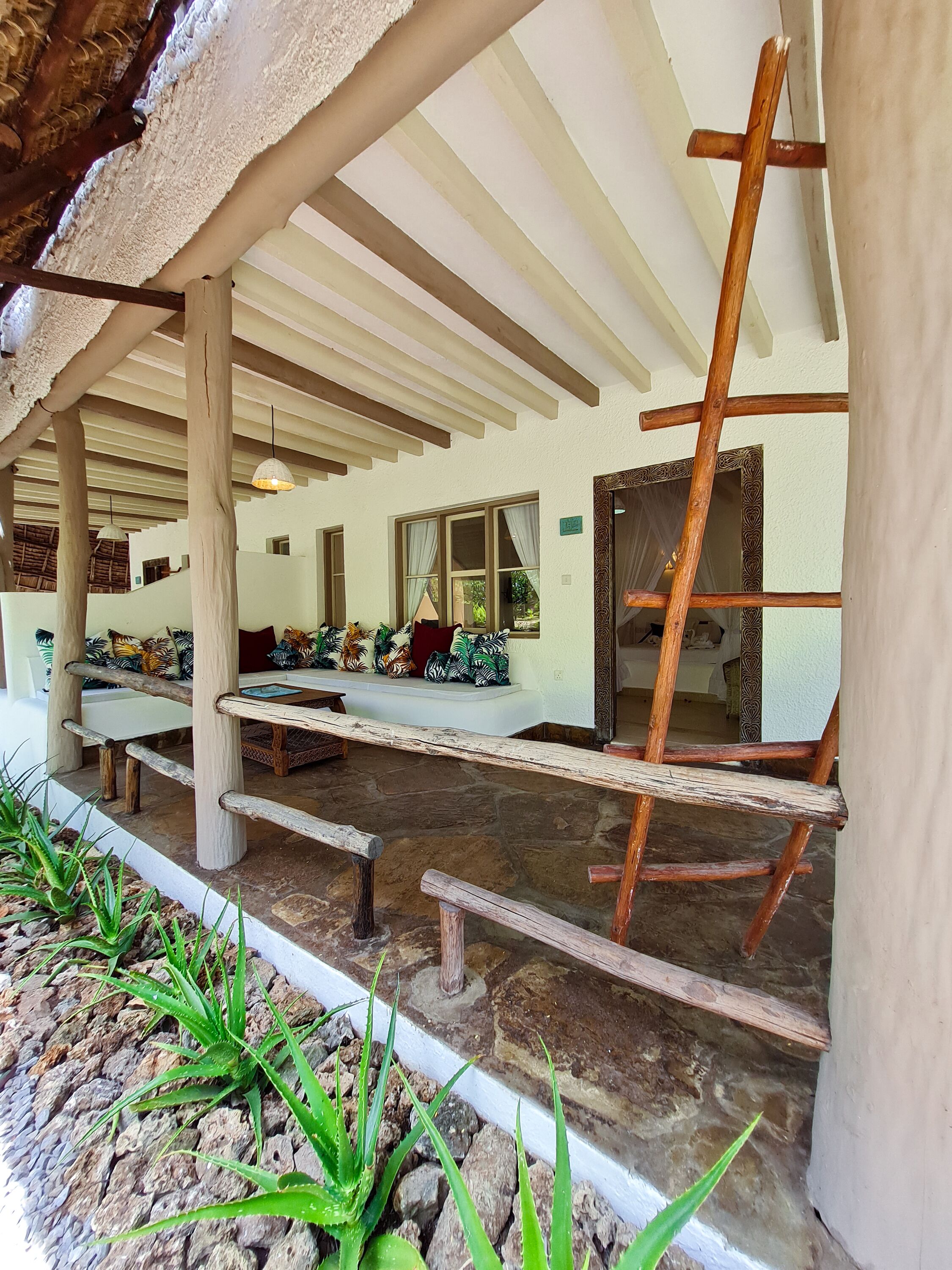 A covered outdoor seating area with wooden benches and a ladder.