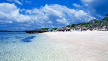 On the beach, white sand, sun-loungers, beach towels
