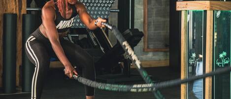 En person træner med kampreb i et fitnesscenter.