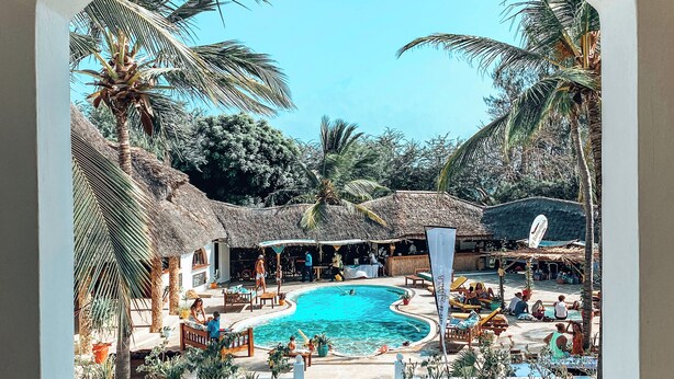 A pool area with lounge chairs and a thatched-roof structure. - Temple Point Resort (Watamu)