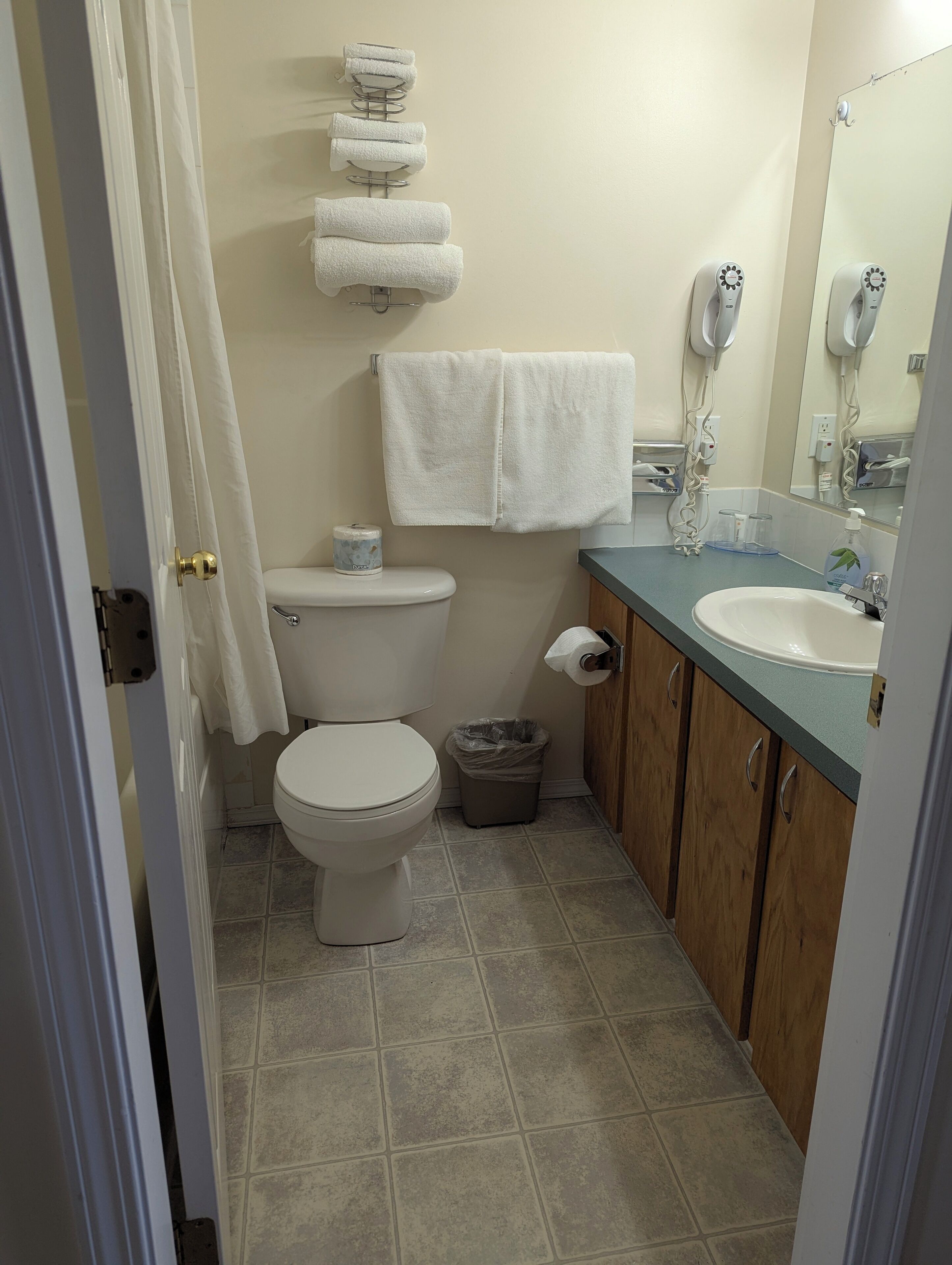 Un baño con inodoro, lavabo y toallero.