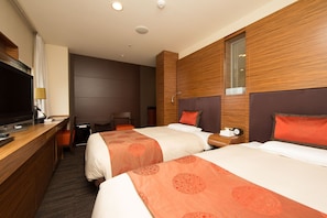 Habitación de hotel con dos camas, televisión, escritorio y silla.