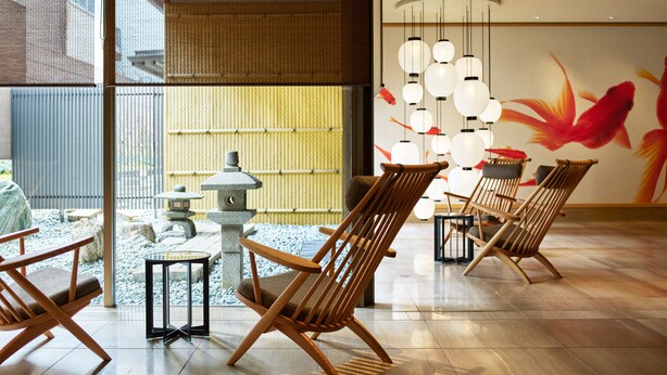 Ein traditionelles japanisches Interieur mit Tatami-Böden, Holzmöbeln und einem Wandbild mit Koi-Karpfen.