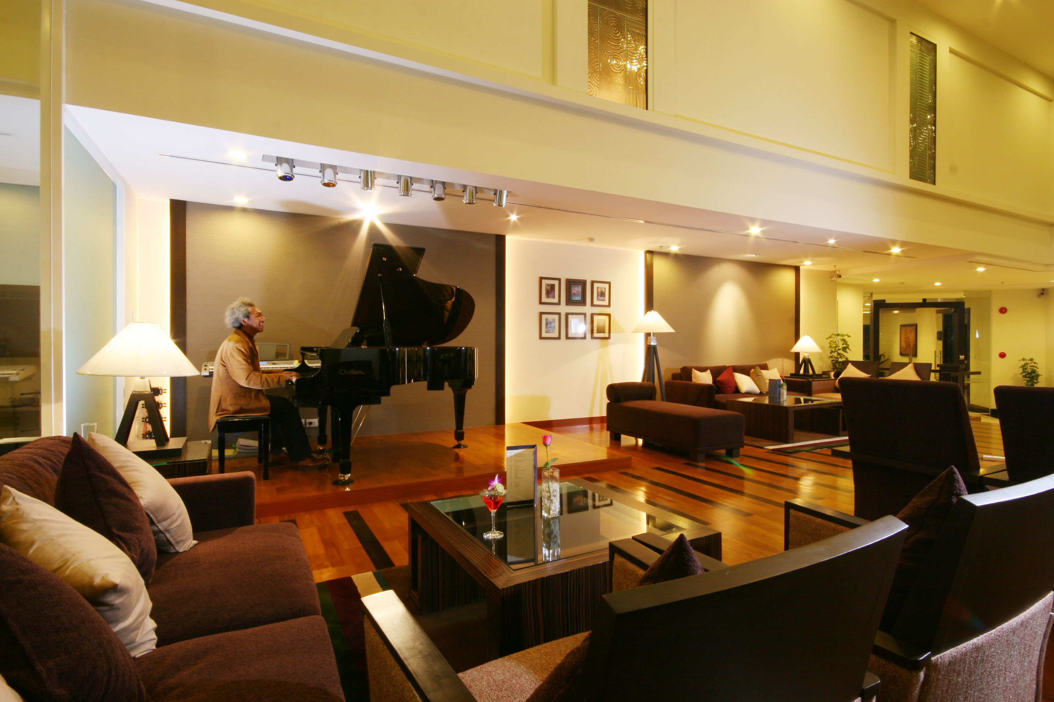 A spacious lobby with a grand piano, comfortable seating, and a modern design.