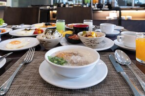 A dining table set with various dishes including a bowl of soup, a plate with an egg, and several bowls of food.