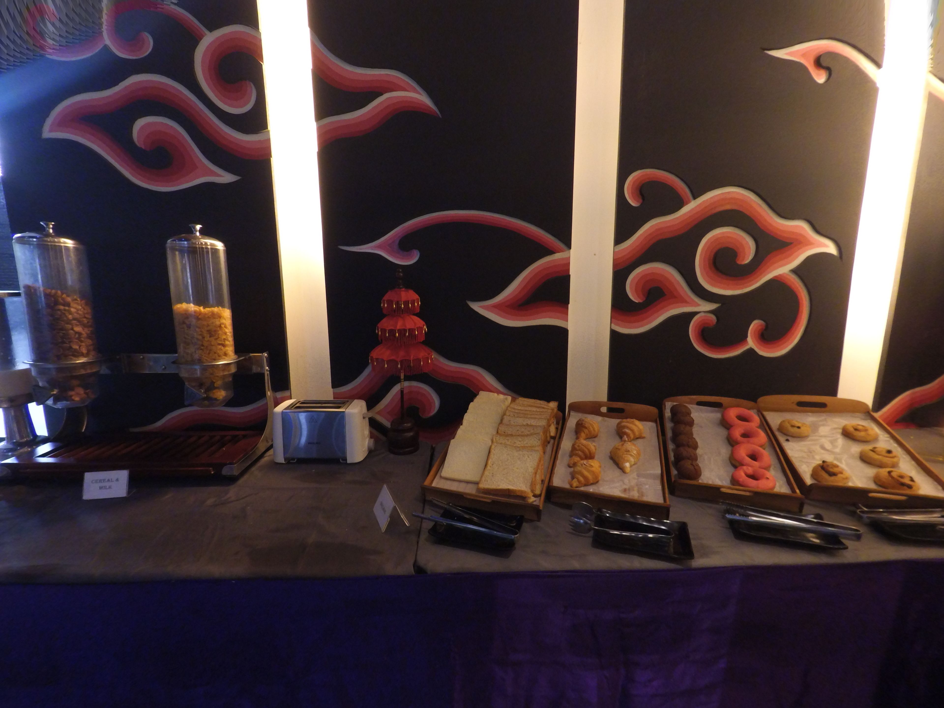 A buffet setup with various food items and a decorative backdrop.