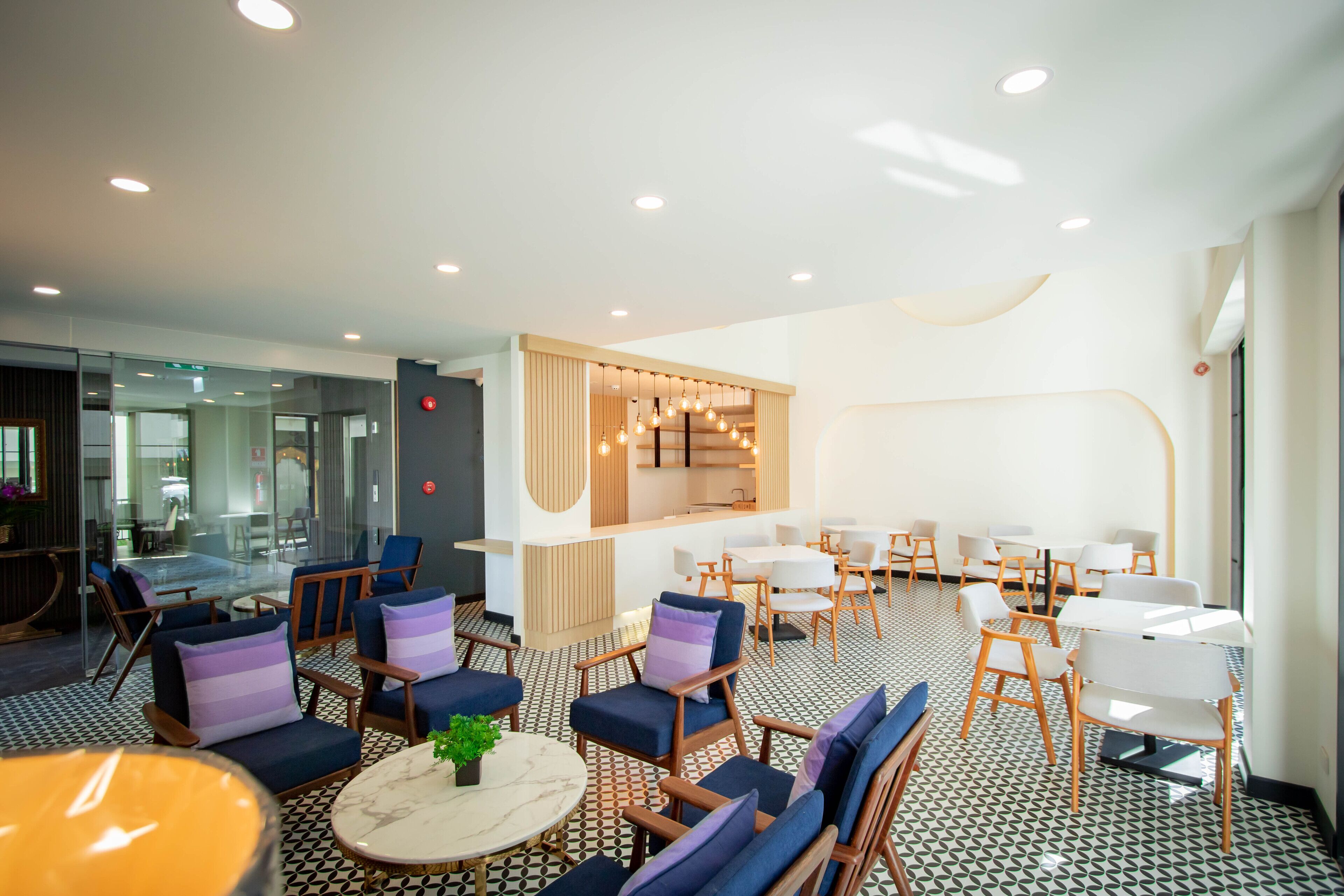 A modern lounge area with seating arrangements, a central bar area, and a patterned floor.