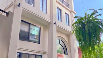 A multi-story building with a balcony, large windows, and a sign that reads "Curana".