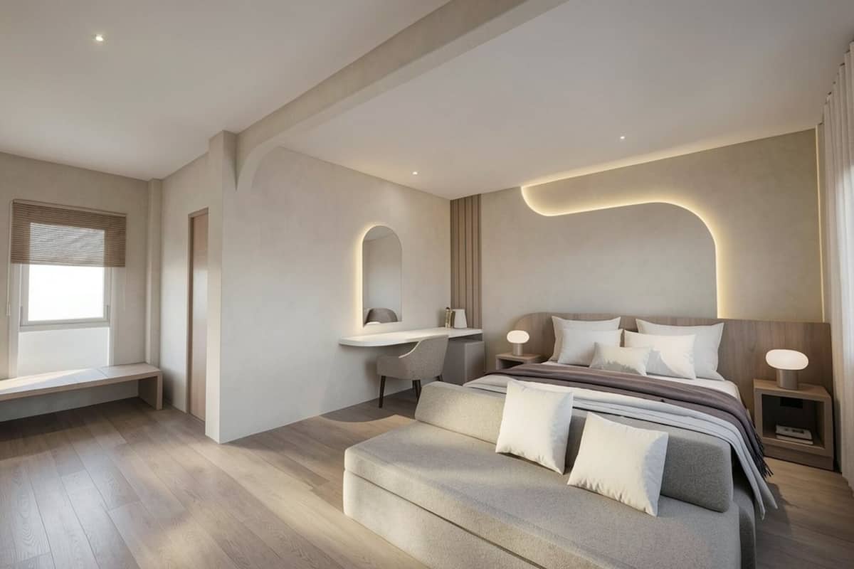 A modern bedroom with a bed, bedside tables, a desk, and a bench.