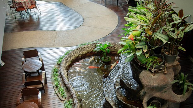 A courtyard with a water feature, seating areas, and potted plants.